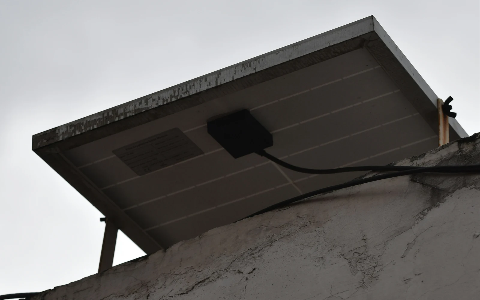 Panneau solaire monté sur une petite toiture sous un ciel nuageux
